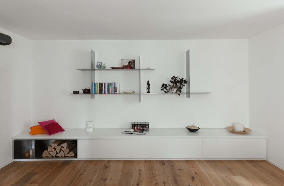 Idee per un soggiorno design di medie dimensioni e aperto con libreria, pareti bianche, pavimento in legno massello medio e stufa a legna