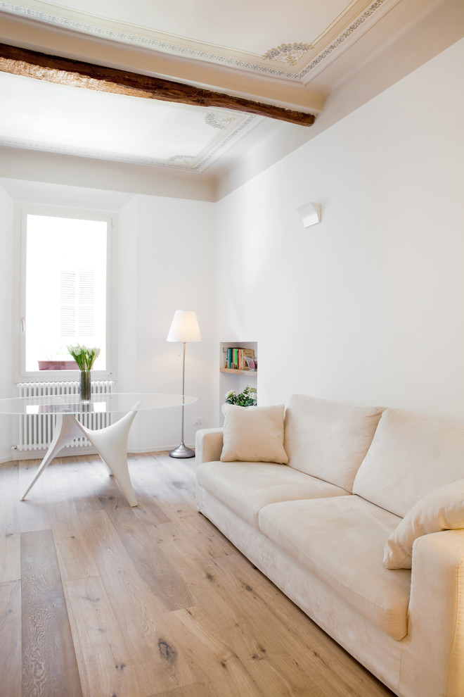 Skandinavisches Wohnzimmer mit weißer Wandfarbe und hellem Holzboden in Bologna