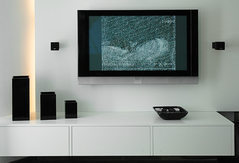 Exempel på ett stort modernt vardagsrum, med vita väggar, marmorgolv, en öppen hörnspis, en spiselkrans i sten, en väggmonterad TV och svart golv