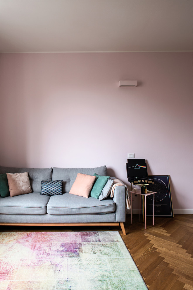 Aménagement d'un salon romantique de taille moyenne et ouvert avec une salle de réception, un mur rose, un sol en bois brun, un téléviseur fixé au mur et un sol marron.
