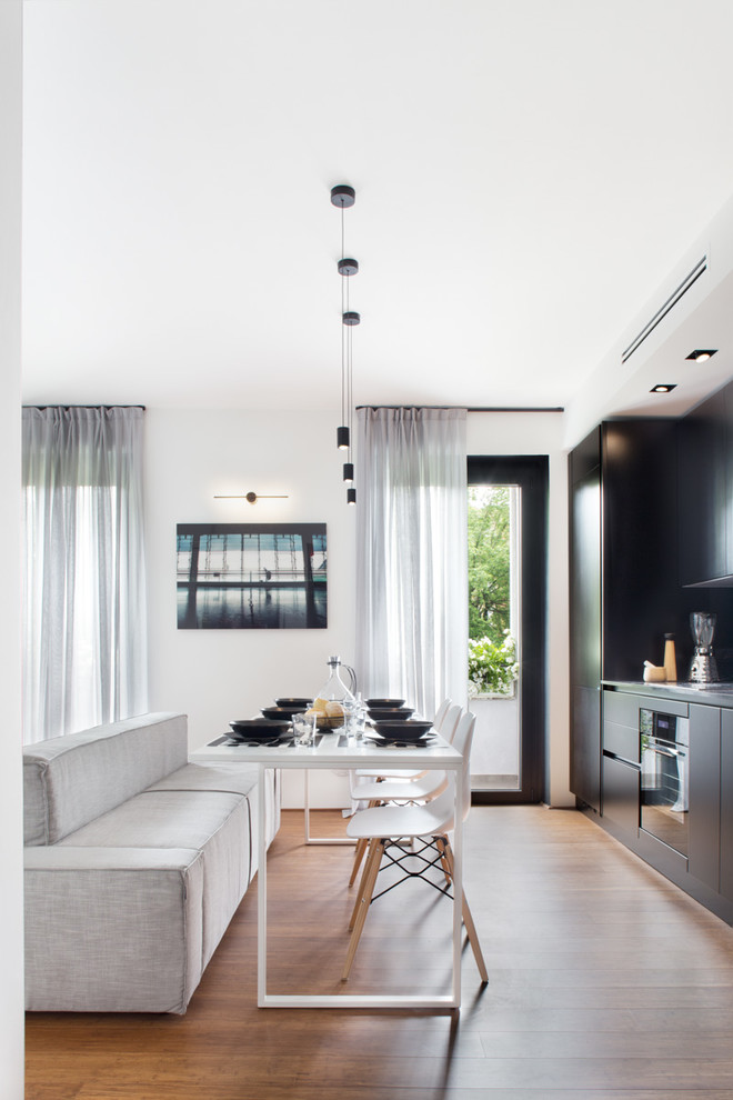 Living room - contemporary open concept medium tone wood floor living room idea in Milan with white walls