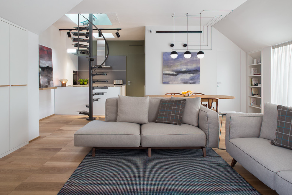 Modelo de salón abierto contemporáneo de tamaño medio con paredes blancas y suelo de madera en tonos medios