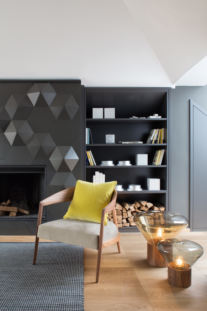 Cette photo montre une salle de séjour tendance de taille moyenne avec une bibliothèque ou un coin lecture, un mur noir, un sol en bois brun, une cheminée ribbon et un manteau de cheminée en plâtre.