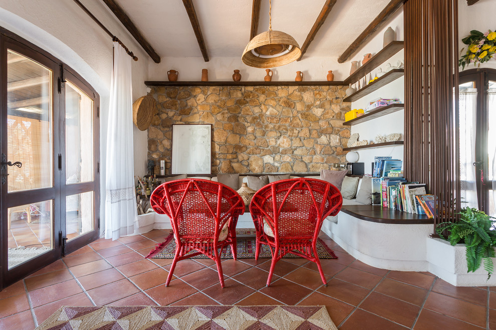 Mediterranes Wohnzimmer mit brauner Wandfarbe, Terrakottaboden und rotem Boden in Sonstige