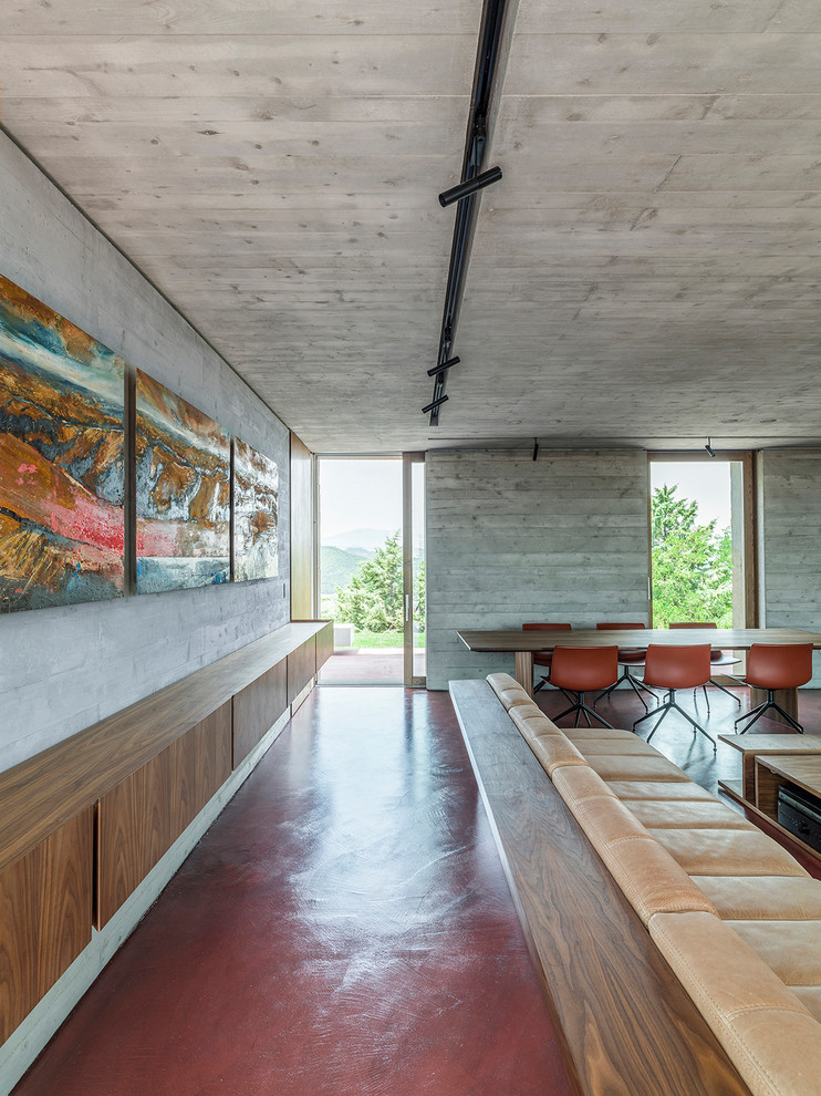 Idées déco pour un grand salon contemporain ouvert avec une salle de réception, sol en béton ciré, un téléviseur encastré et un sol rouge.