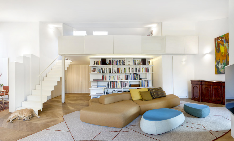 Cette image montre une salle de séjour design ouverte avec un mur blanc, parquet clair et un sol beige.