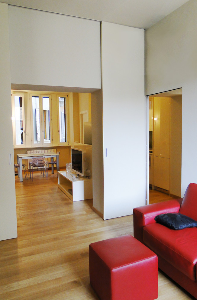 Diseño de sala de estar con biblioteca abierta contemporánea de tamaño medio con paredes blancas, suelo de madera en tonos medios, televisor independiente y suelo marrón