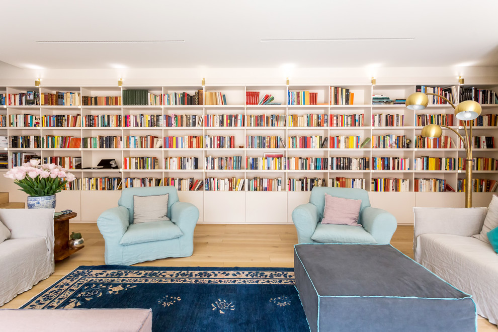 Bild på ett funkis vardagsrum, med ett bibliotek, vita väggar, ljust trägolv och beiget golv