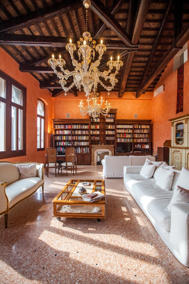 Foto på ett mycket stort vintage vardagsrum, med orange väggar, en standard öppen spis, brunt golv och ett bibliotek