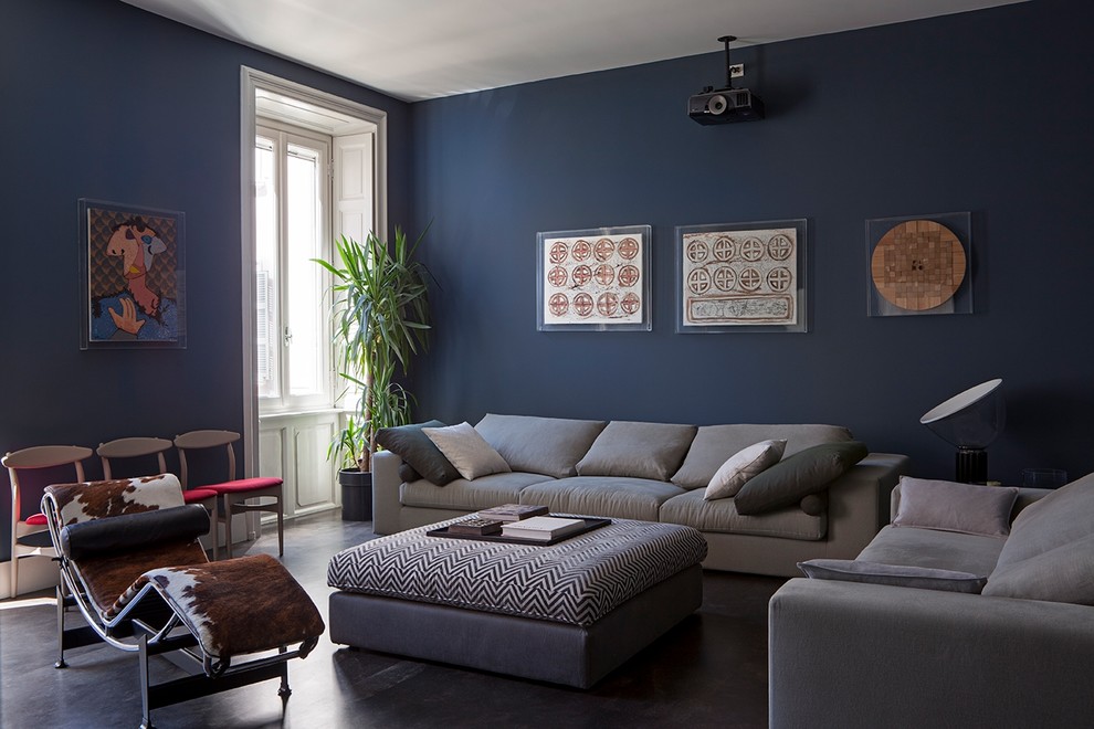 Cette image montre un salon design avec un mur bleu, sol en béton ciré et un sol gris.