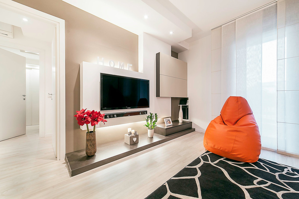 Immagine di un soggiorno design chiuso con parquet chiaro, TV a parete e pareti beige