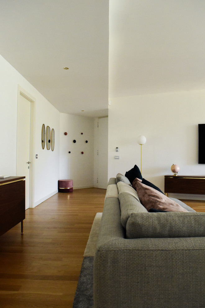Idées déco pour une très grande salle de séjour contemporaine ouverte avec un mur blanc, parquet clair, un téléviseur fixé au mur et un sol marron.
