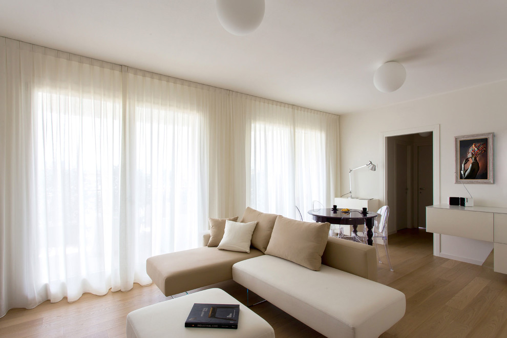 Idee per un soggiorno design aperto con pareti bianche e parquet chiaro