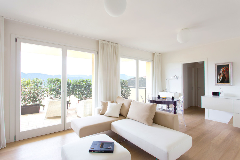 Esempio di un soggiorno minimal aperto con pareti bianche, parquet chiaro e pavimento beige