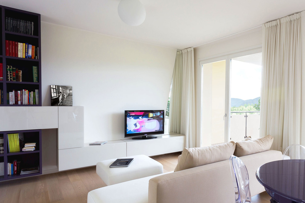 На фото: открытая гостиная комната в современном стиле с белыми стенами, светлым паркетным полом и отдельно стоящим телевизором с