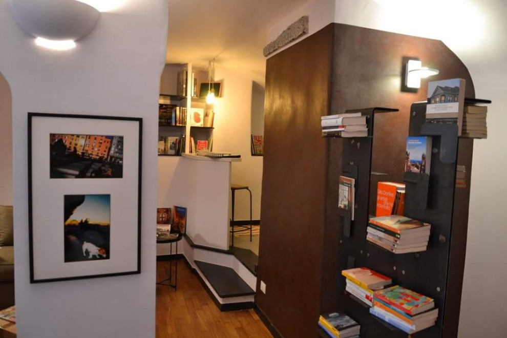Cette image montre un petit salon mansardé ou avec mezzanine design avec un bar de salon, un mur beige, un sol en bois brun, un téléviseur indépendant et un sol marron.