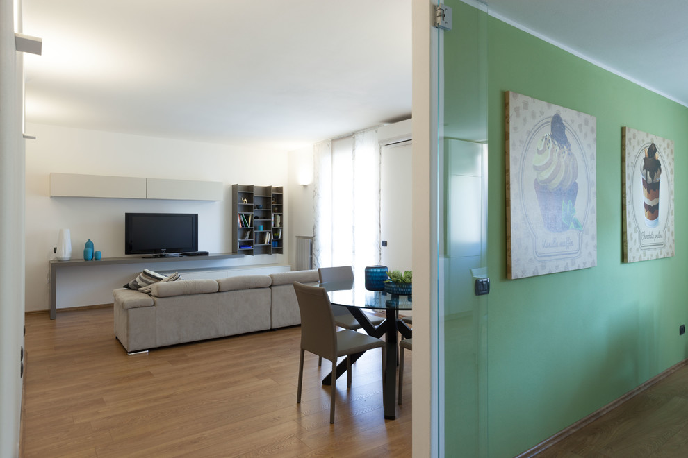 Immagine di un soggiorno minimal di medie dimensioni e aperto con pareti grigie, pavimento in laminato e TV autoportante