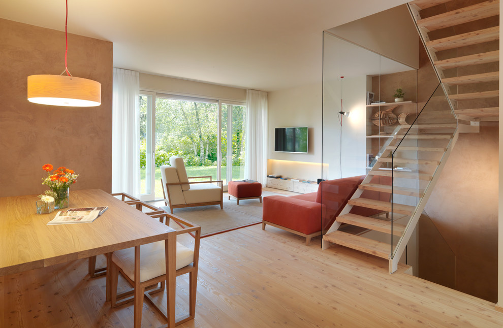 Ejemplo de salón abierto minimalista grande con paredes blancas y suelo de madera clara