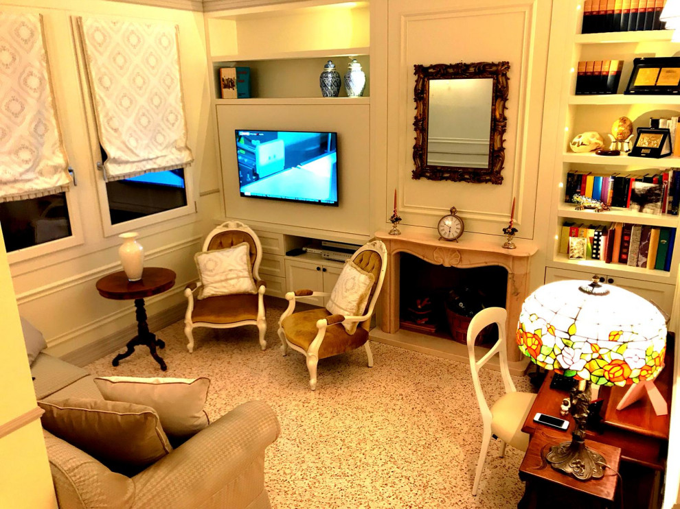 Immagine di un soggiorno classico di medie dimensioni e chiuso con libreria, pareti bianche, camino classico, cornice del camino in pietra e TV a parete