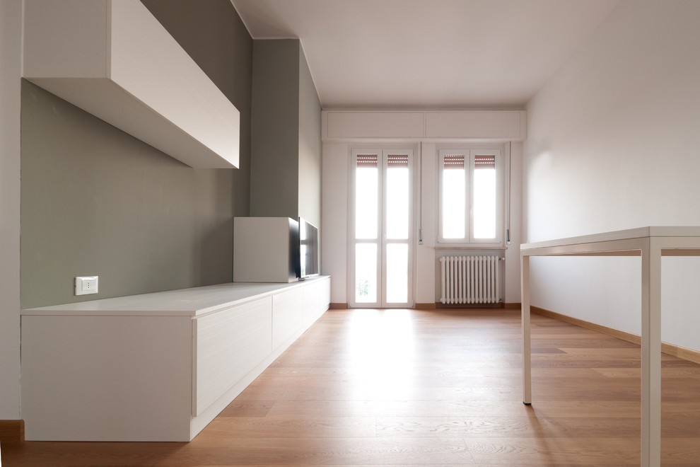 Großes, Offenes Modernes Wohnzimmer mit grauer Wandfarbe, braunem Holzboden und TV-Wand in Mailand