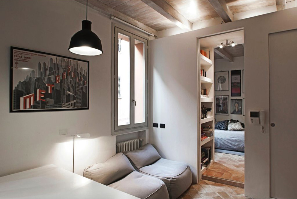 Imagen de sala de estar abierta moderna pequeña con paredes blancas y suelo de ladrillo