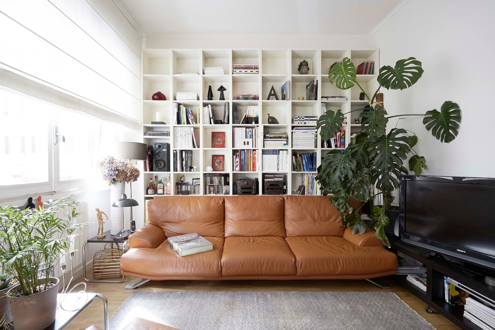 Ispirazione per un soggiorno moderno di medie dimensioni e chiuso con pareti bianche, parquet chiaro e TV autoportante