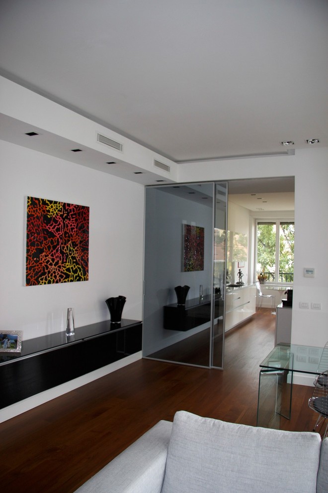 Large midcentury formal enclosed living room in Milan with white walls, dark hardwood flooring, brown floors and a drop ceiling.