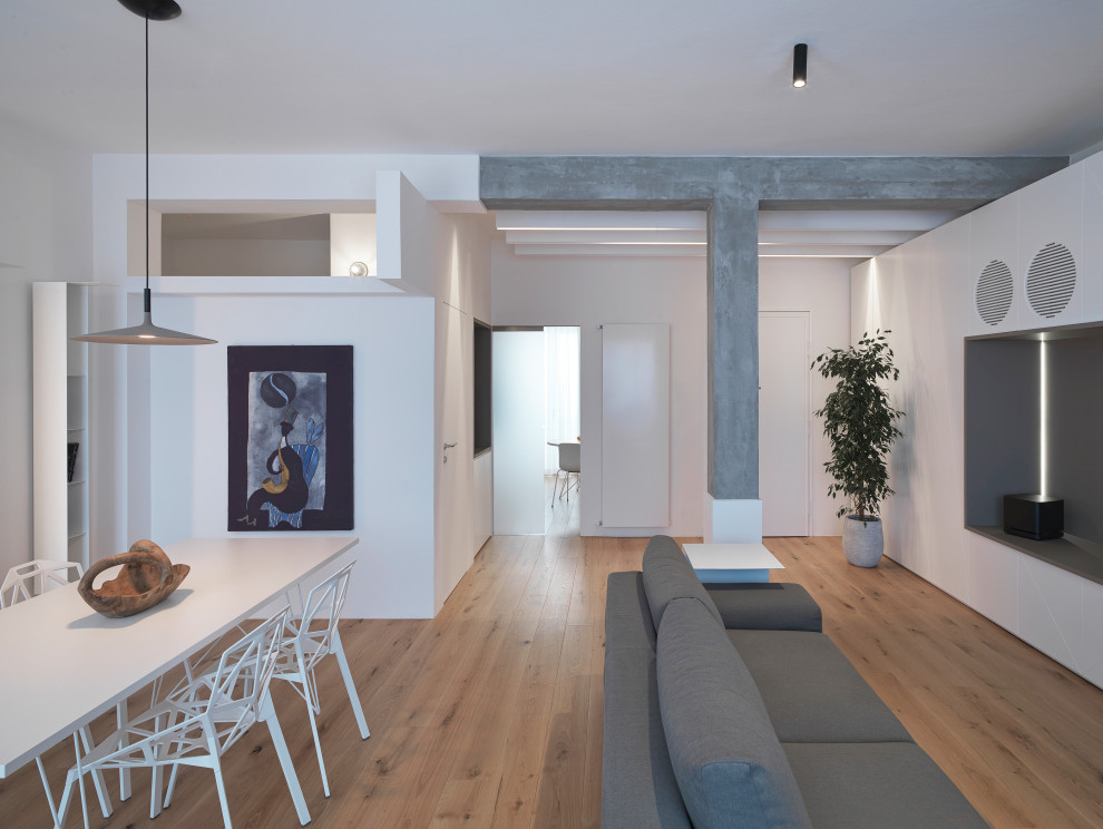 На фото: изолированная гостиная комната среднего размера в современном стиле с белыми стенами, мультимедийным центром, паркетным полом среднего тона и коричневым полом без камина