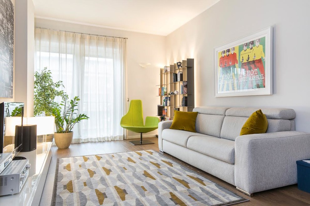 На фото: изолированная гостиная комната среднего размера в современном стиле с отдельно стоящим телевизором, коричневым полом, серыми стенами и паркетным полом среднего тона без камина