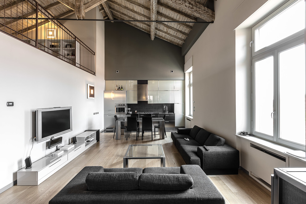 Diseño de salón para visitas actual extra grande con paredes blancas, suelo de madera clara y televisor colgado en la pared