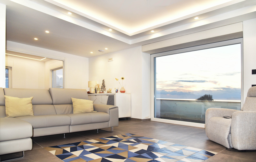 Ispirazione per un grande soggiorno mediterraneo aperto con pareti bianche, pavimento in gres porcellanato e pavimento grigio
