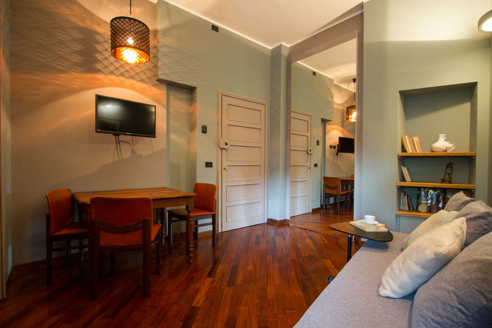 Immagine di un piccolo soggiorno moderno aperto con pareti multicolore, pavimento in legno massello medio, TV a parete e pavimento marrone