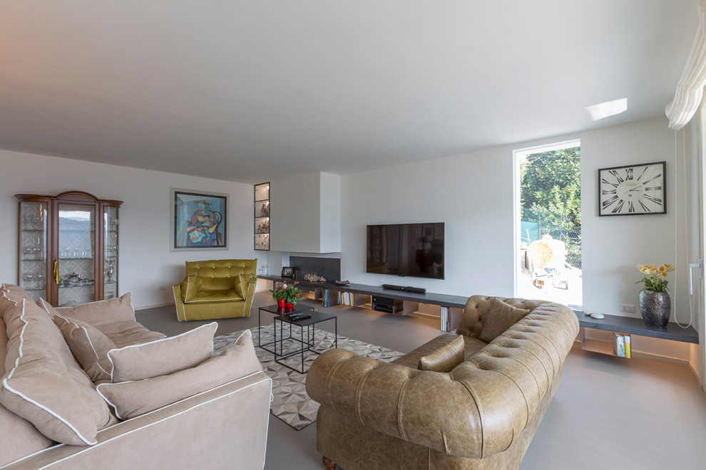Esempio di un soggiorno contemporaneo aperto con pareti bianche, TV a parete, pavimento grigio e con abbinamento di divani diversi