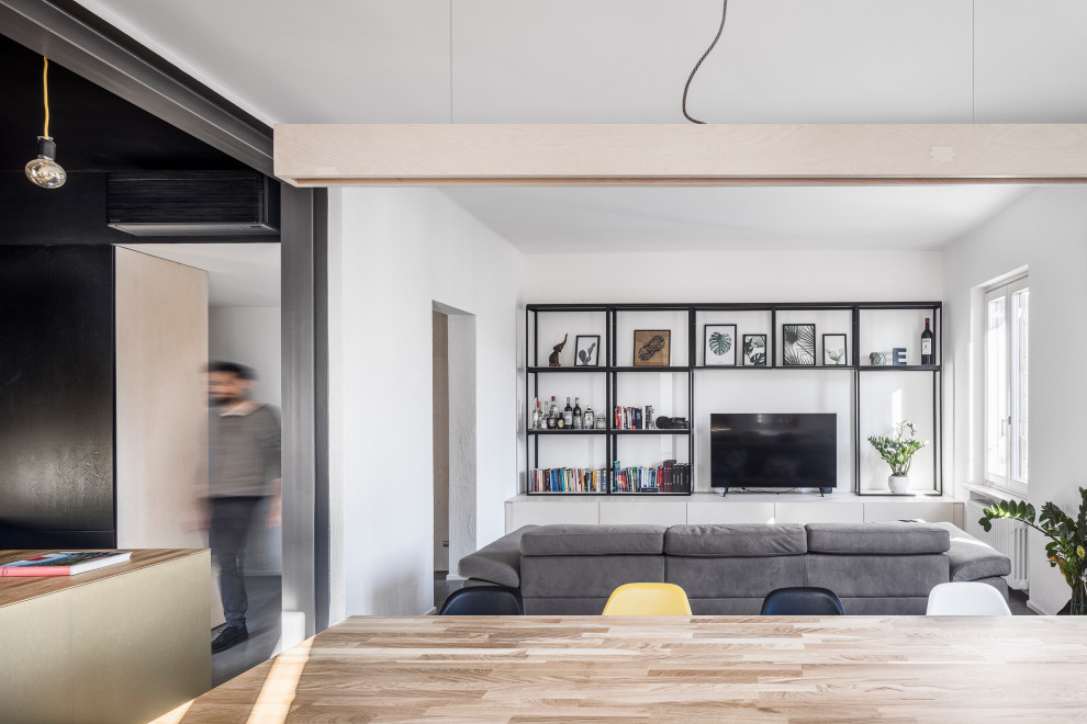 Idee per un soggiorno shabby-chic style di medie dimensioni e aperto con libreria, pareti bianche, pavimento in cemento, TV a parete e pavimento grigio