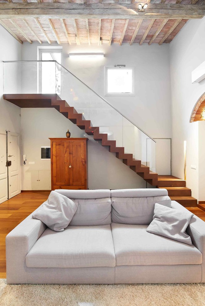 Aménagement d'un salon contemporain ouvert avec un mur blanc et un sol en bois brun.