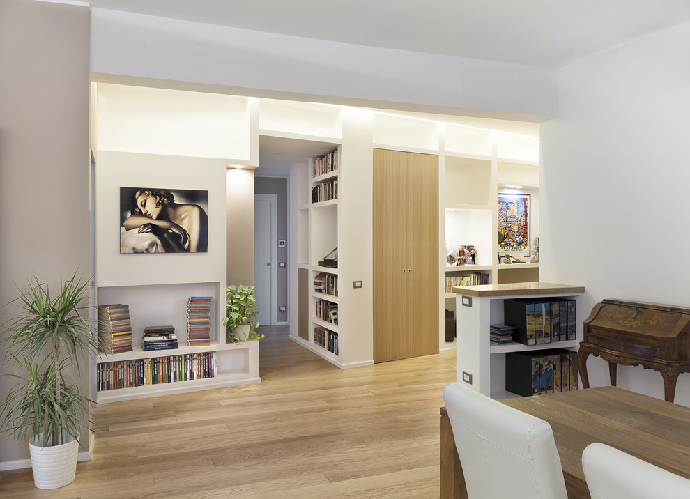 На фото: открытая гостиная комната в стиле модернизм с с книжными шкафами и полками, бежевыми стенами и светлым паркетным полом