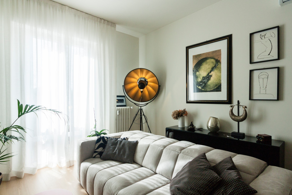 Immagine di un soggiorno minimal di medie dimensioni e aperto con libreria, pareti beige, parquet chiaro, parete attrezzata e pavimento beige
