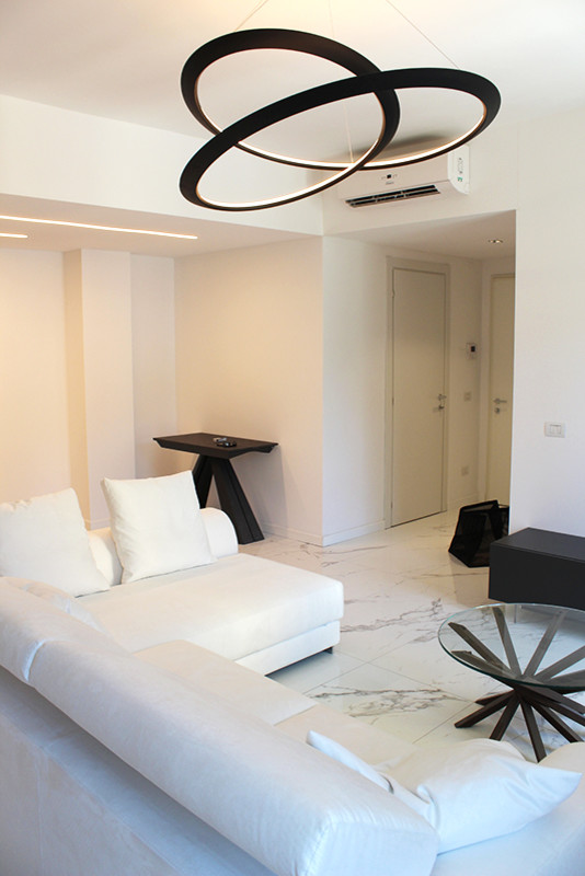Diseño de sala de estar cerrada minimalista con paredes blancas, suelo de baldosas de porcelana, televisor colgado en la pared y suelo blanco