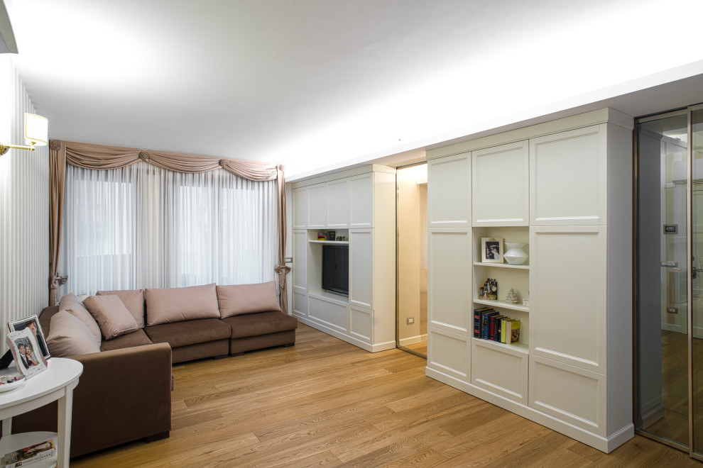 Foto di un grande soggiorno classico aperto con pareti bianche, parquet chiaro, parete attrezzata e pavimento marrone