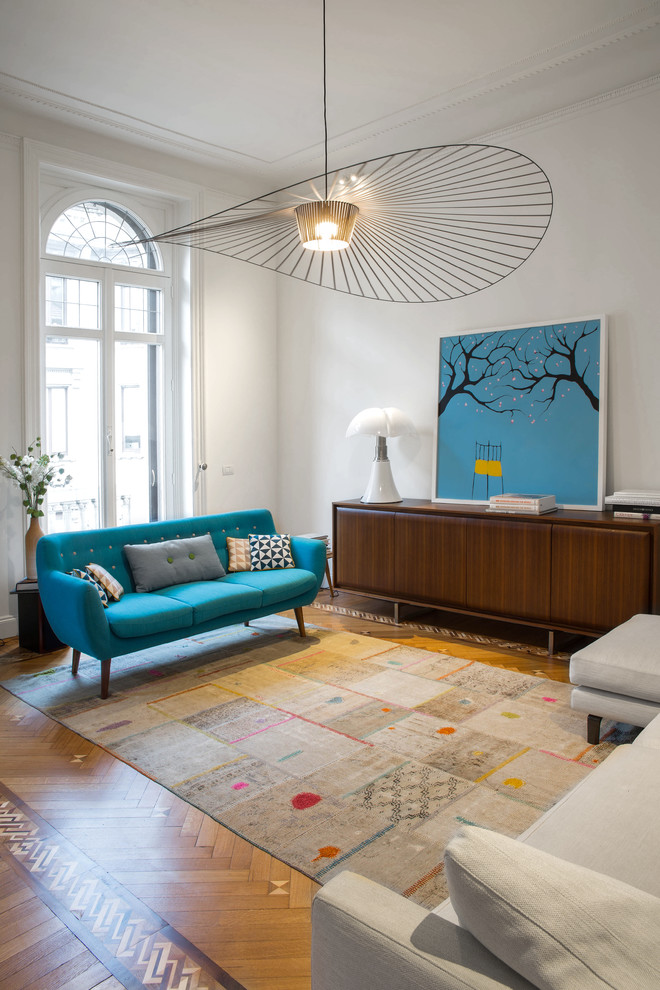 Foto di un ampio soggiorno design aperto con pareti bianche, pavimento in legno massello medio e pavimento multicolore