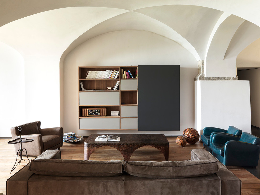 Cette photo montre un grand salon tendance ouvert avec un mur blanc, un sol en bois brun et un téléviseur dissimulé.