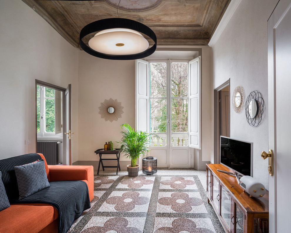 フィレンツェにあるお手頃価格の中くらいなミッドセンチュリースタイルのおしゃれなファミリールーム (白い壁、据え置き型テレビ、マルチカラーの床、暖炉なし) の写真