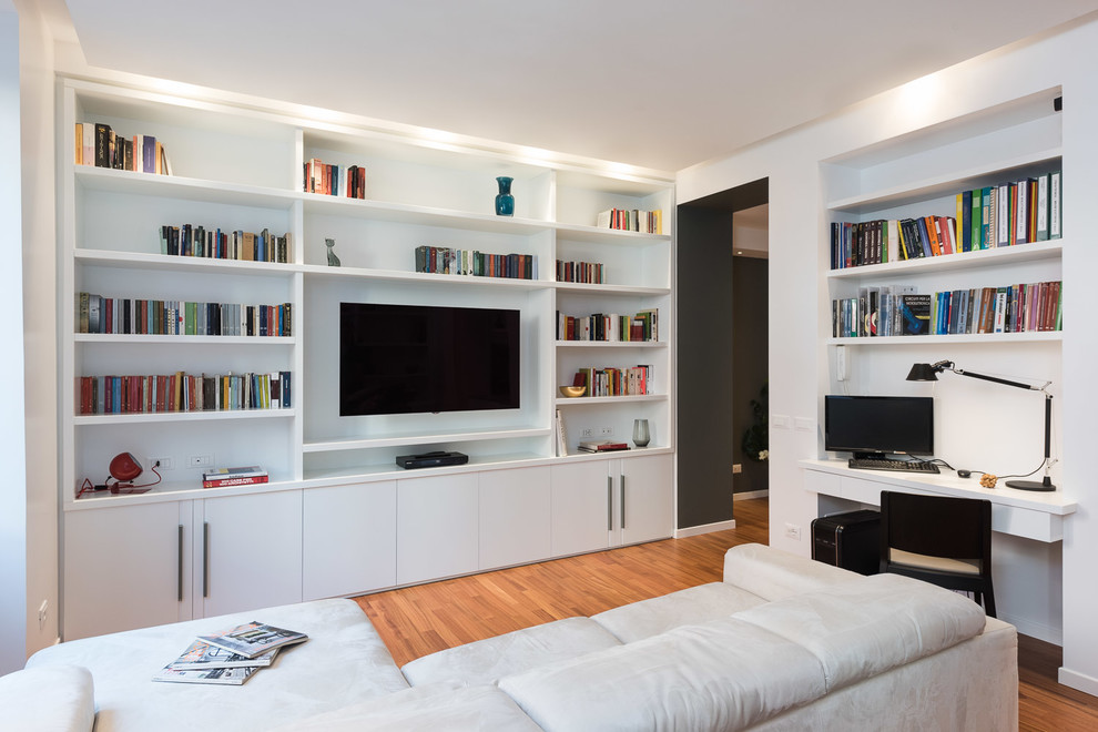 Aménagement d'une salle de séjour contemporaine fermée avec un mur blanc, un sol en bois brun, un téléviseur encastré et un sol marron.