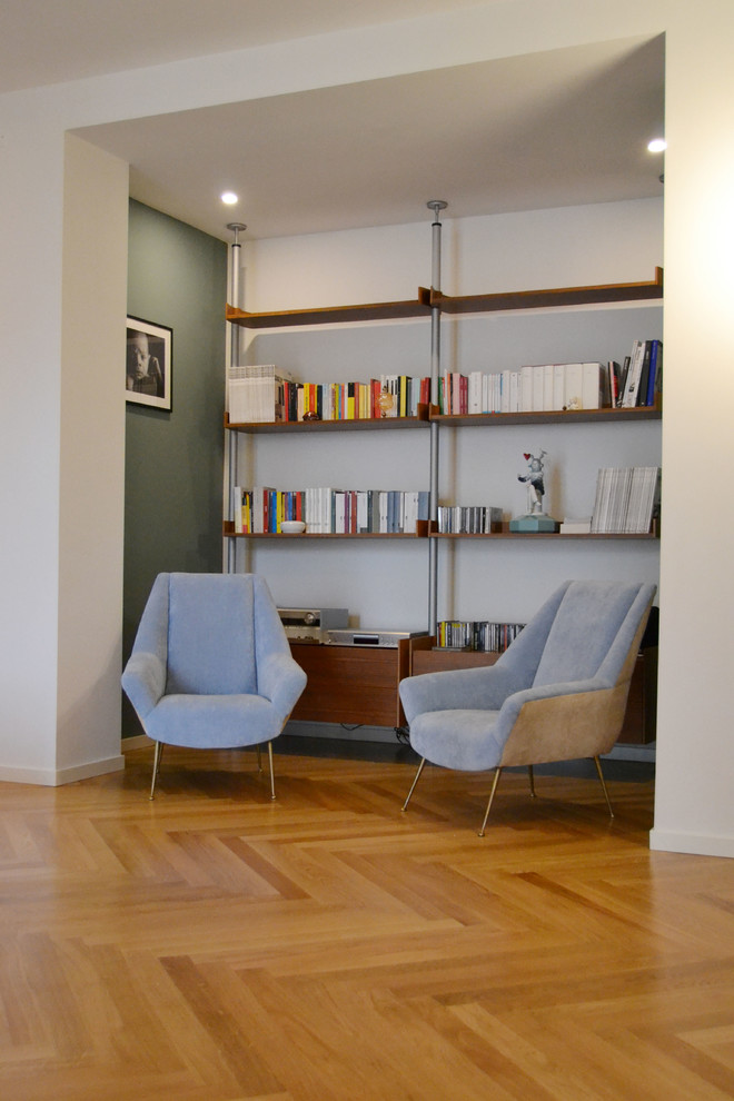 Inspiration för små moderna allrum med öppen planlösning, med ett bibliotek, blå väggar, ljust trägolv och en väggmonterad TV