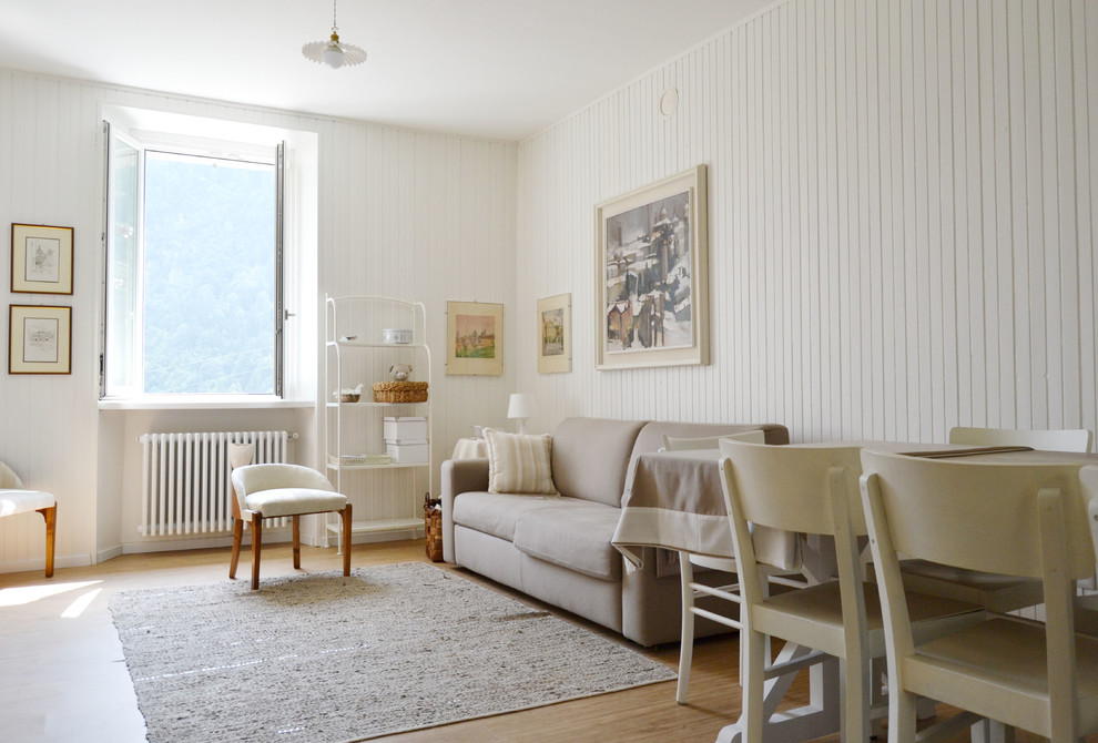 Retro inredning av ett mellanstort vardagsrum, med vita väggar och ljust trägolv