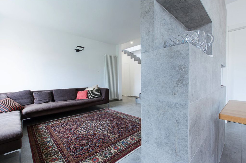 Bild på ett mellanstort funkis allrum med öppen planlösning, med vita väggar, klinkergolv i porslin, en väggmonterad TV och grått golv