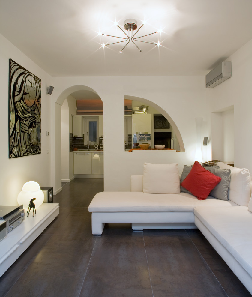 ミラノにある低価格の広いコンテンポラリースタイルのおしゃれな独立型ファミリールーム (白い壁、磁器タイルの床、吊り下げ式暖炉、漆喰の暖炉まわり、コーナー型テレビ、グレーの床) の写真