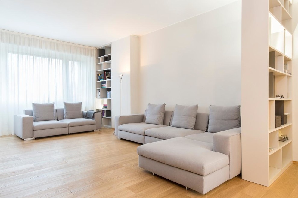 Minimalist open concept light wood floor living room library photo in Milan with gray walls and no tv