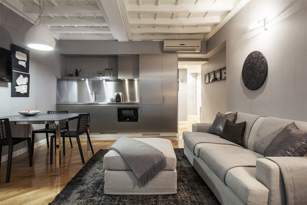 Idee per un grande soggiorno design aperto con pareti grigie e parquet chiaro