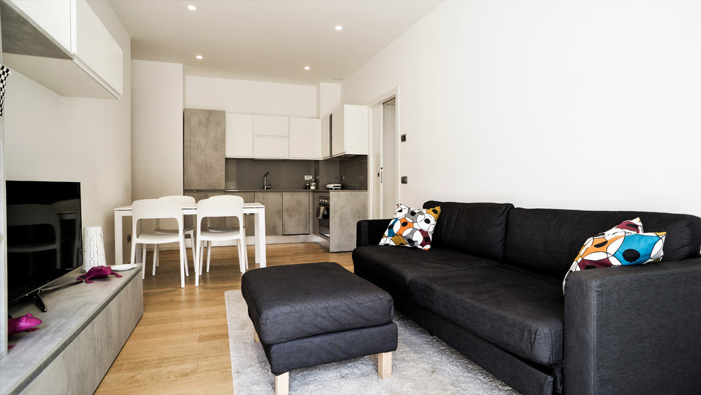 Esempio di un soggiorno minimal aperto con pareti bianche, parquet chiaro, TV autoportante e pavimento beige